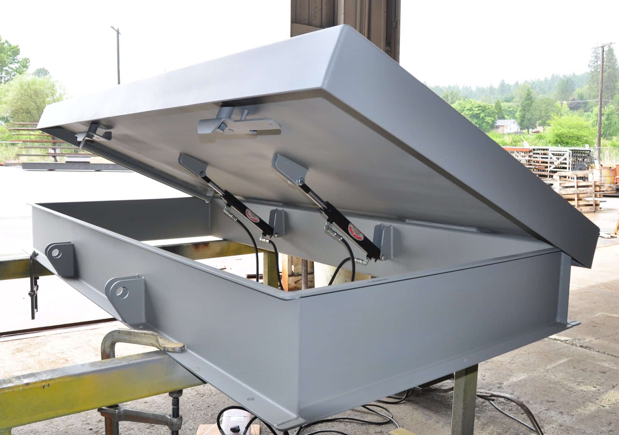 Flat in ground storm shelter hatch with hydraulic lift assist, the latch type that needs a seasonal check